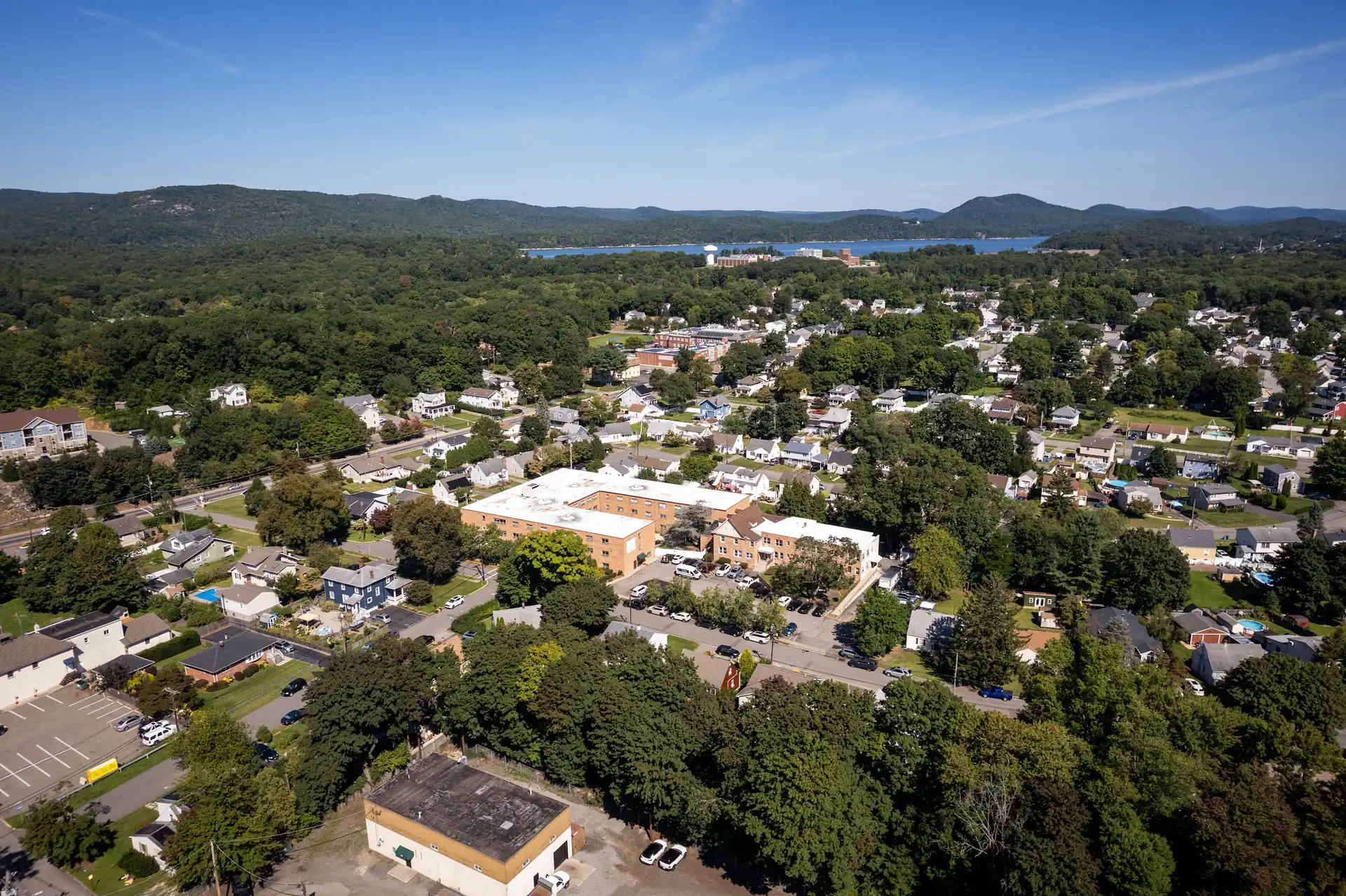 Aerial view of the Amara Rehab and Nursing campus in Haskell, New Jersey, with wooded hills and the reservoir beyond