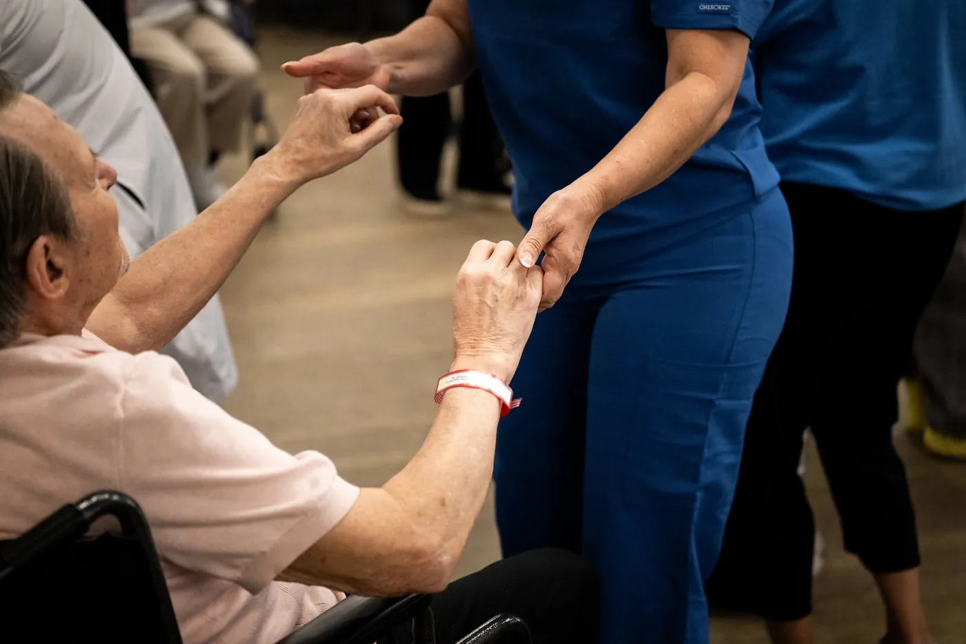 Caregiver holding a resident's hand during an activity