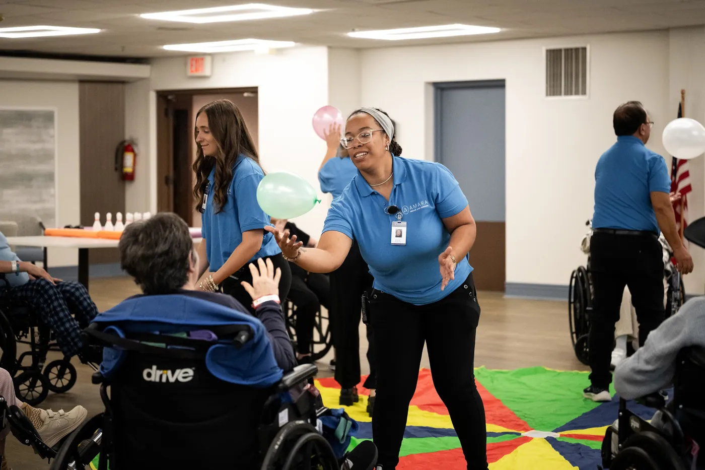 Team members leading a lively group activity with residents in the dayroom