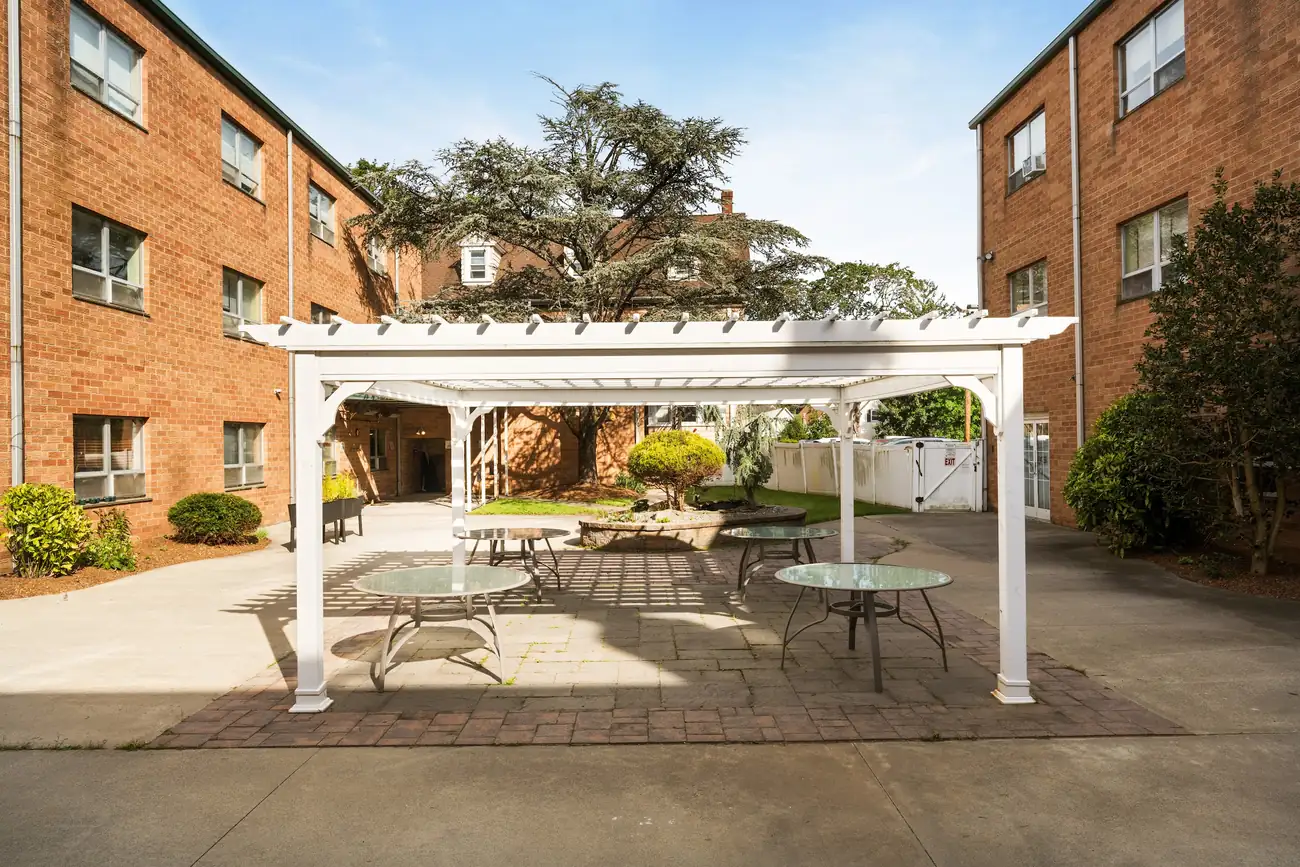 Courtyard patio with a white pergola and outdoor seating