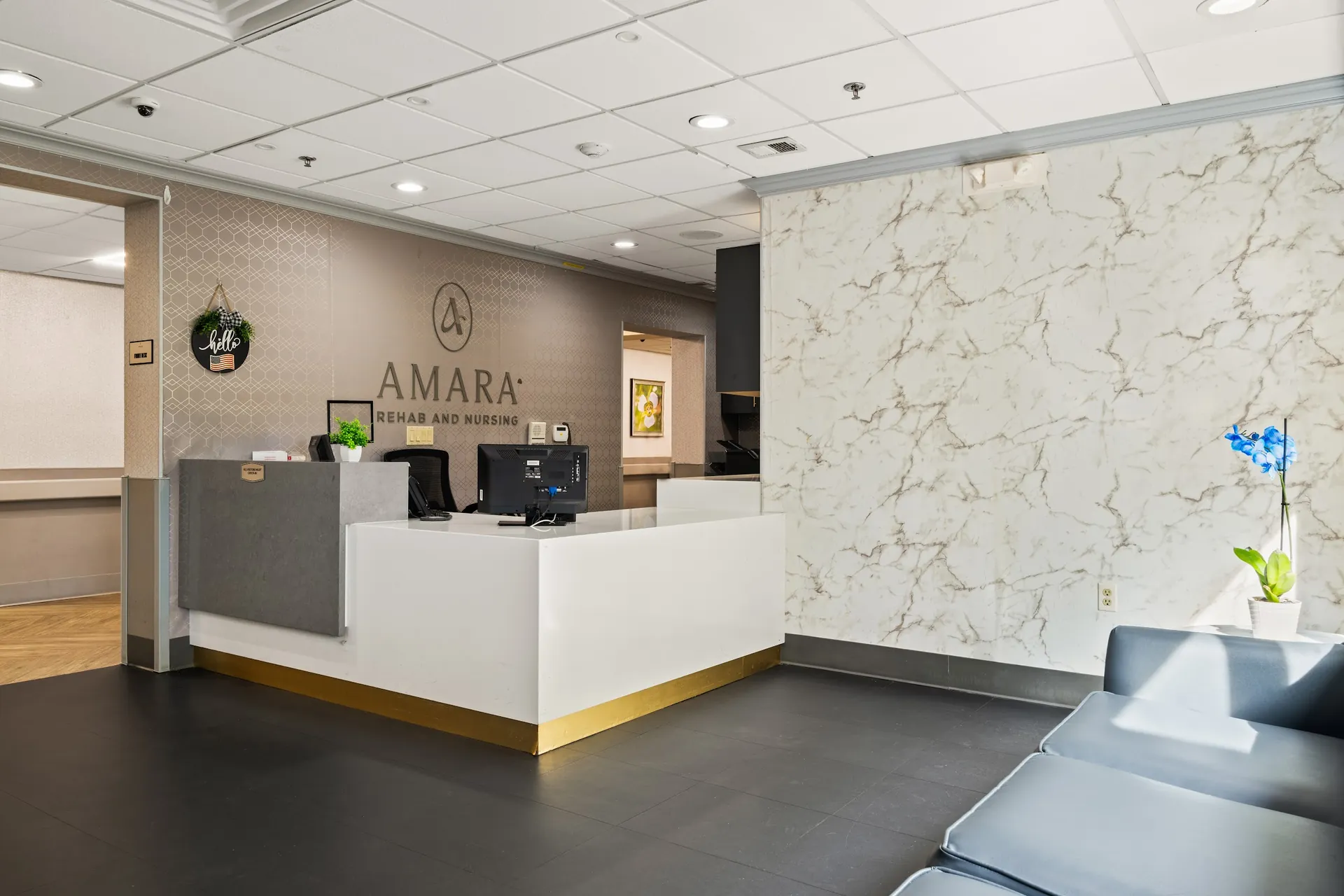 Amara Rehab and Nursing reception desk with illuminated AMARA sign, orchids and a starlit blue ceiling