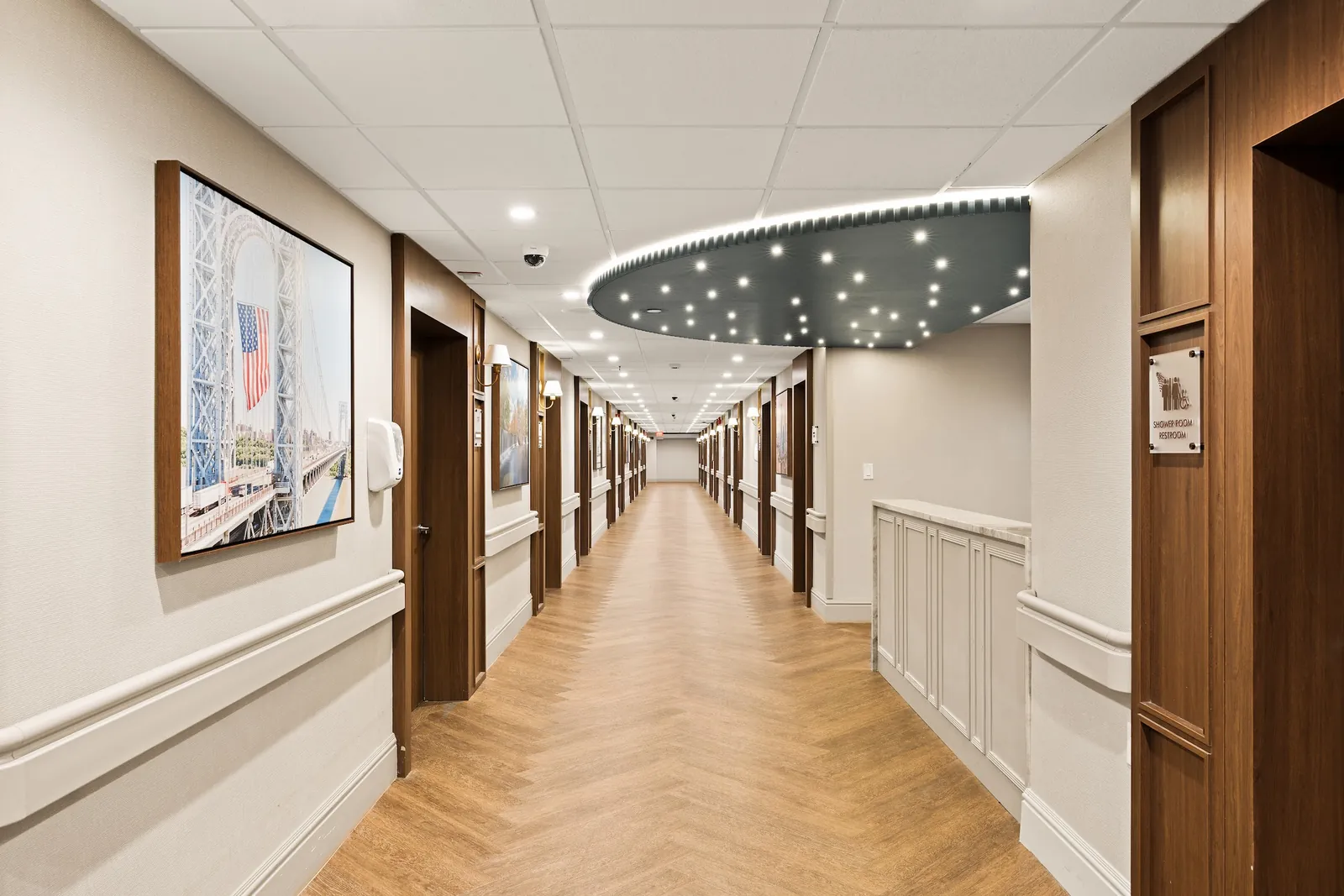 Newly renovated corridor with herringbone floors and framed artwork