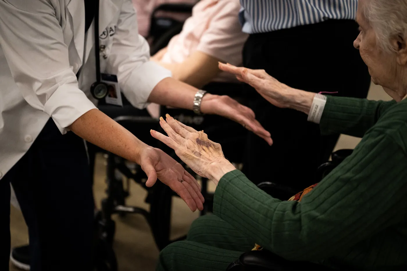 Physician gently supporting a resident's outstretched hands