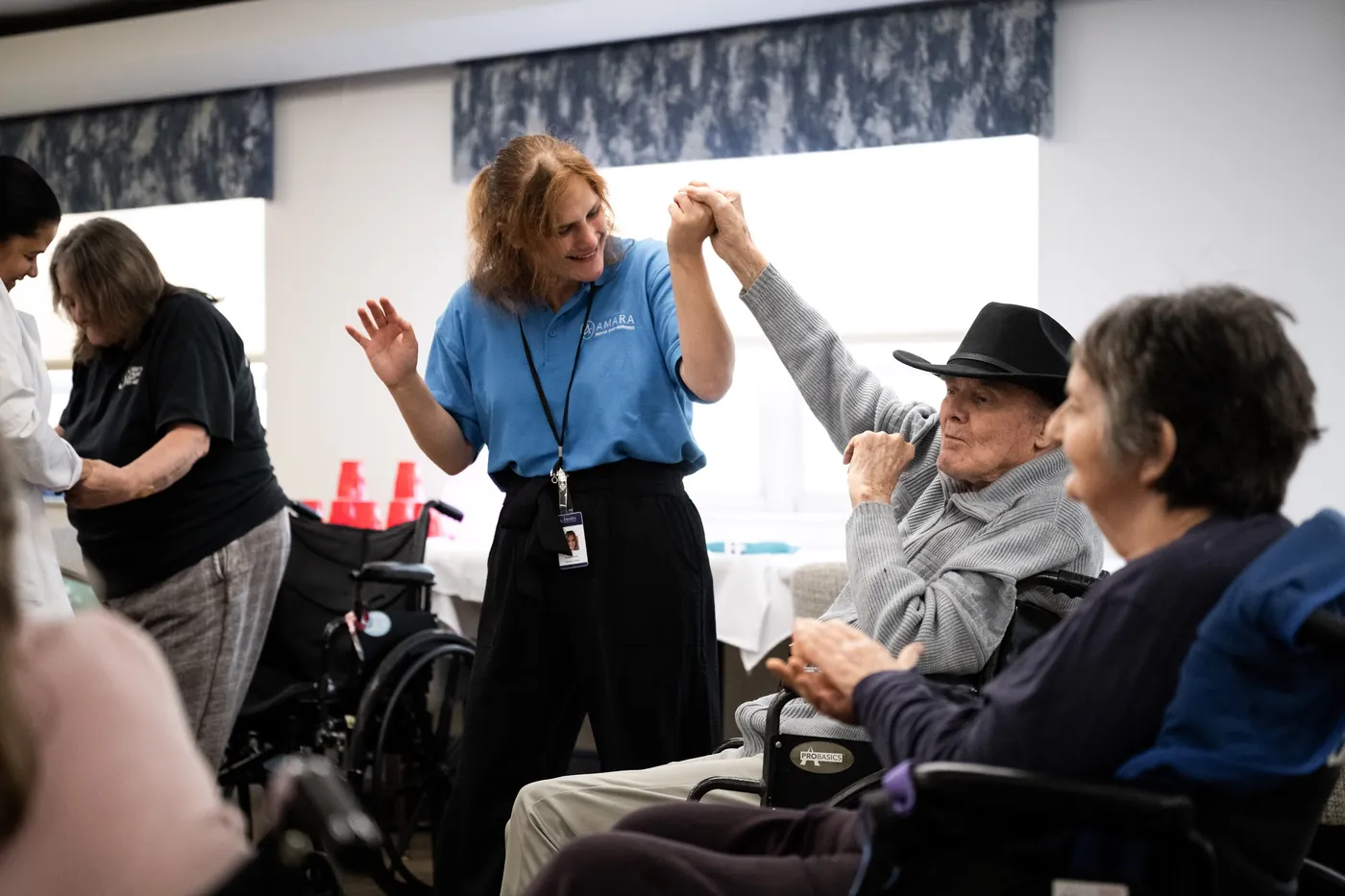 Team member dancing hand in hand with a smiling resident during an activity